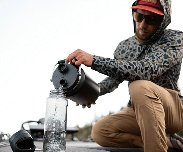 Man filling his yeti water bottle on a fishing dock