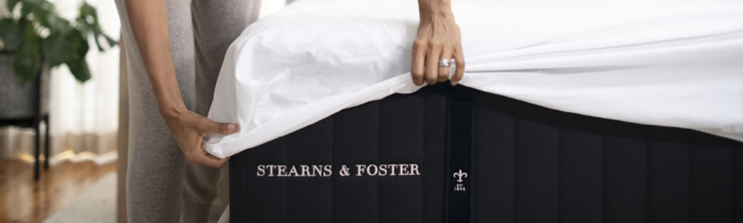 Woman putting sheets on a Stearns & Foster mattress